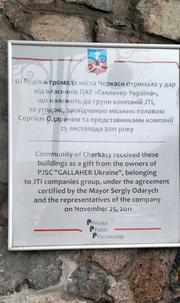 Інформаційна табличка на стіні колишньої тютюнової фабрики в Черкасах про дарування будівель громаді міста від компанії JTI у 2011 році за угодою з мером Сергієм Одаричем